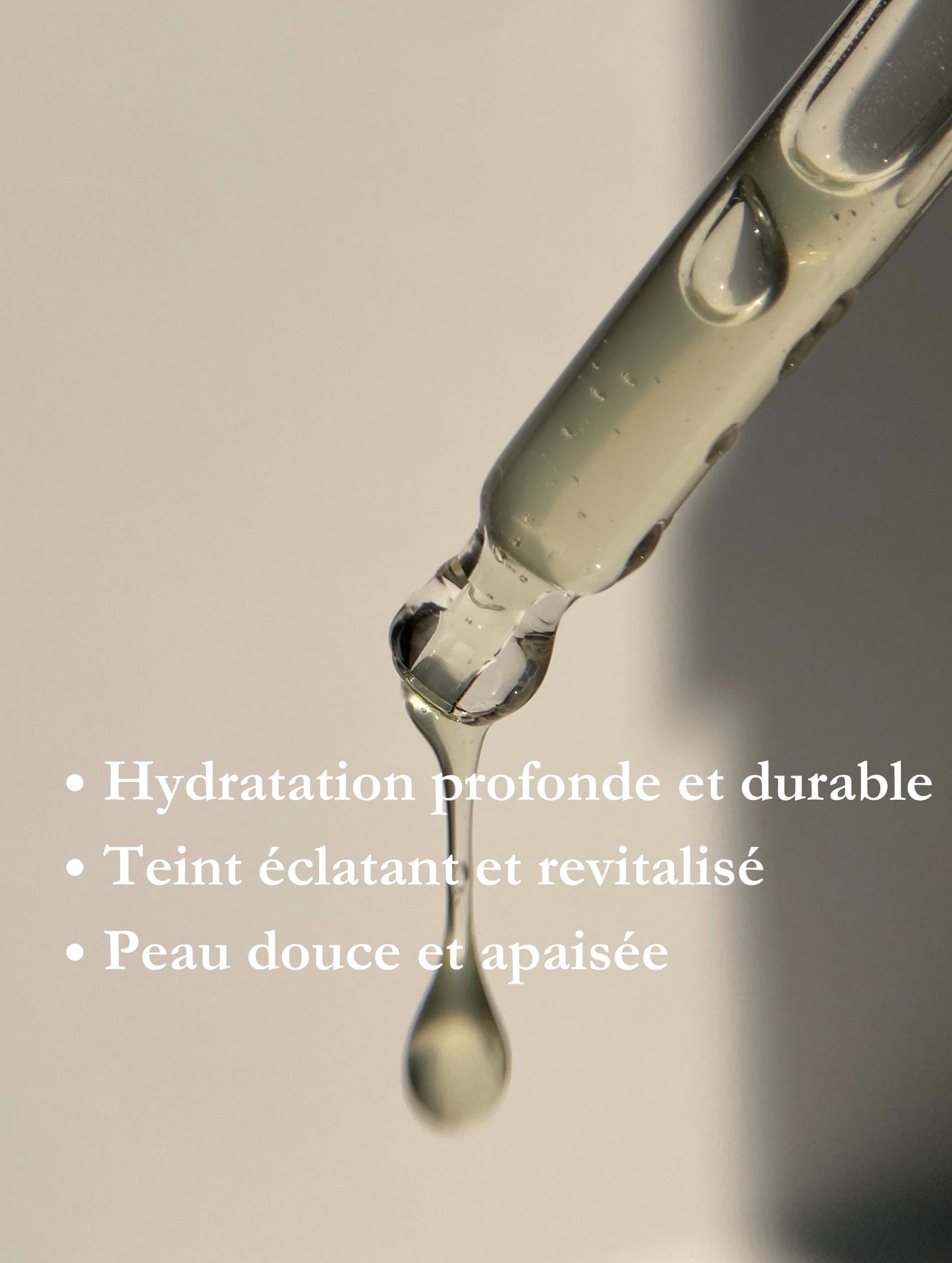 Goutte de sérum hydratant et revitalisant tombant d'une pipette, illustrant les bienfaits d'une peau éclatante, douce et apaisée.